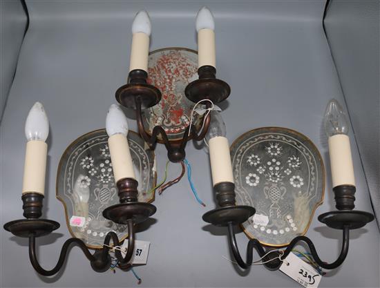 A toilet mirror and three mirrored wall sconces
